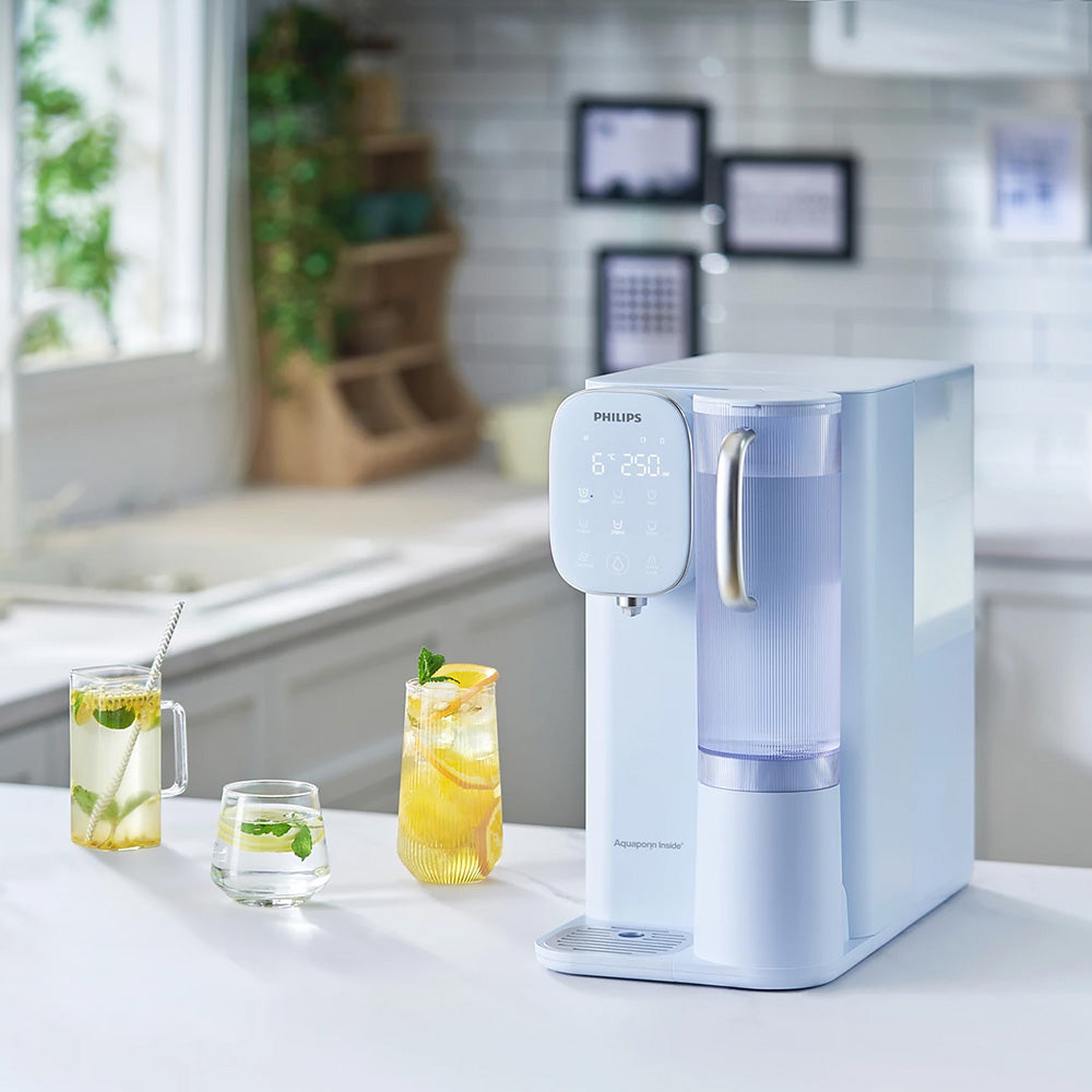 Philips 即熱式冷熱飲水機，出水口旁放置玻璃杯與飲品